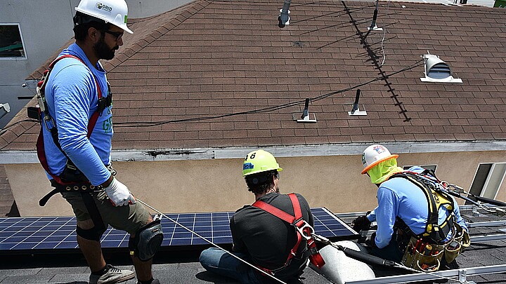 Trabajadores instalando paneles solares en una vivienda