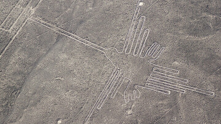 Aerial view of geoglyphs near Nazca - famous Nazca Lines, Peru. In the center, a hummingbird figure is present.