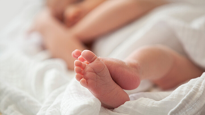 Pequeños pies de bebé en un recién nacido durmiente
