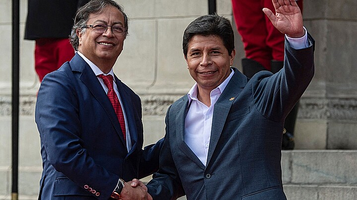 El presidente de Colombia Gustavo Petro (L) y el expresidente peruano Pedro Castillo (R) dan la mano