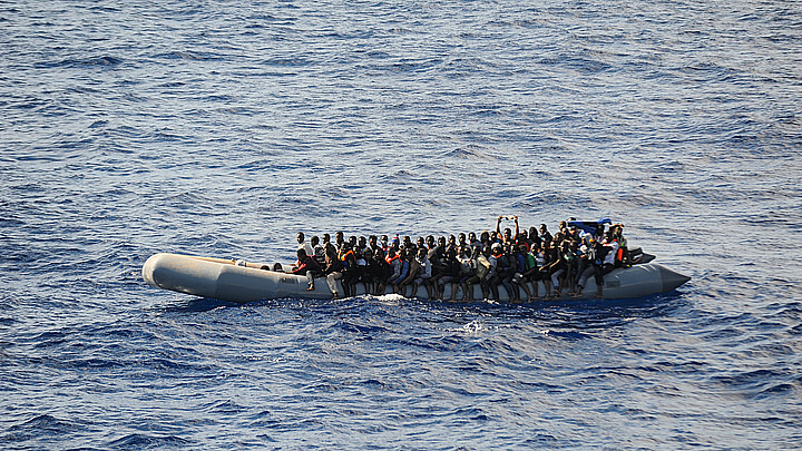 Una pequeña embarcación de goma llena de inmigrantes