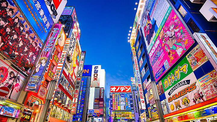 Crowds pass below colorful signs in Akihabara, Japan 