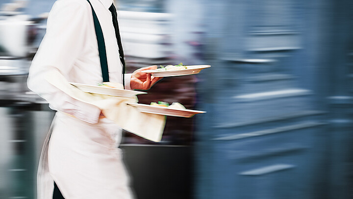 Stock image of waiter serving food in restaurant