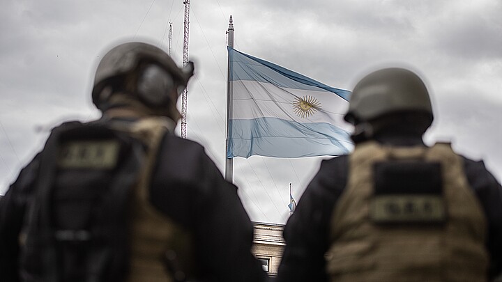 bandera nacional argentina se ve a través de dos oficiales de las fuerzas tácticas