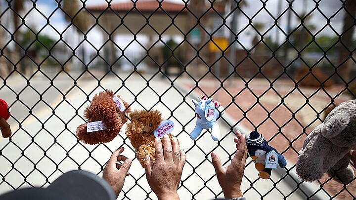 Fotografía de archivo de unas personas que cuelgan de manera simbólica unos muñecos de peluche como manera de representar la inocencia de los niños