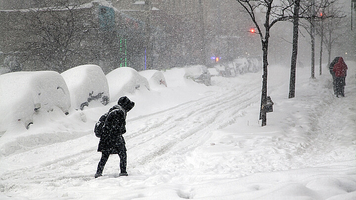Mujer cruza la calle durante la tormenta de nieve Jonas