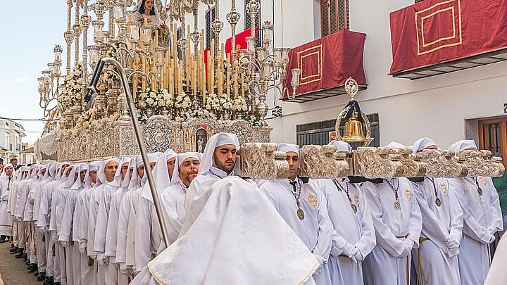 VELEZ-MALAGA, ESPAÑA - 25 DE MARZO DE 2018: Procesión de personas en la semana santa. Los residentes que participan en la procesión usan plataformas con imágenes de santos.