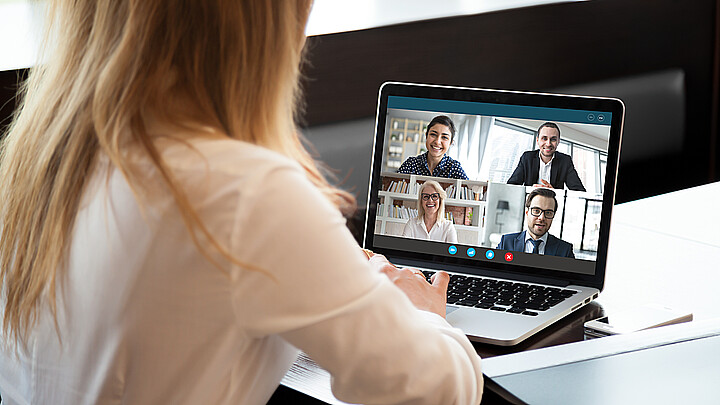 Vista posterior de las mujeres de negocios hablando usando la conferencia Webcam