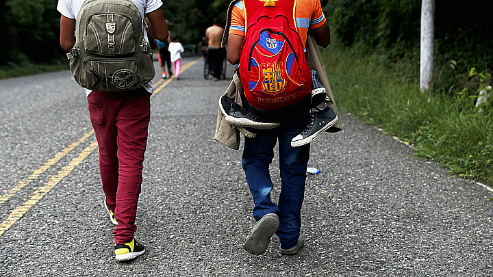 Dos jovenes migrantes caminando