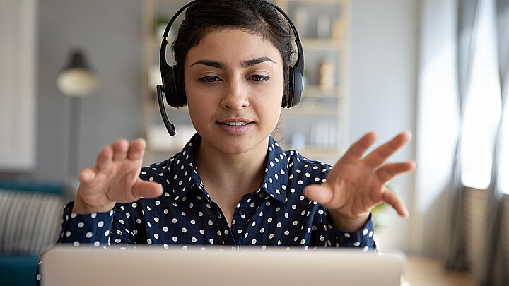 Joven mujer en una videoconferencia con auriculares