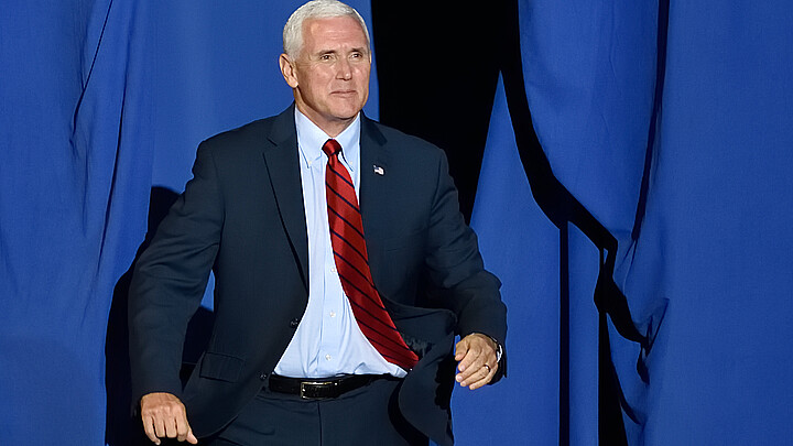 Vice President Mike Pence "bursts" through the opening on stage at a rally in 2017