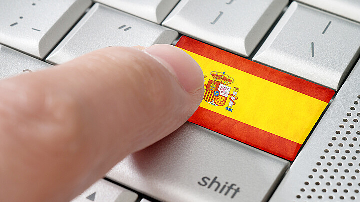 A computer keyboard in English features a Spanish flag
