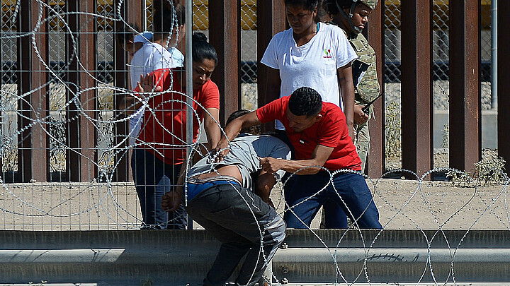 Migrantes ilegales cruzan alambrada