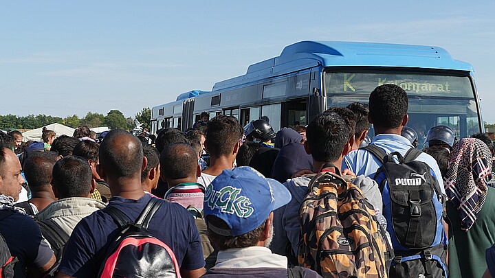 Migrants waiting to board bus