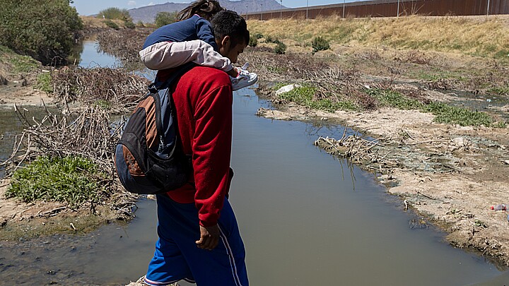 Migrants crossing river