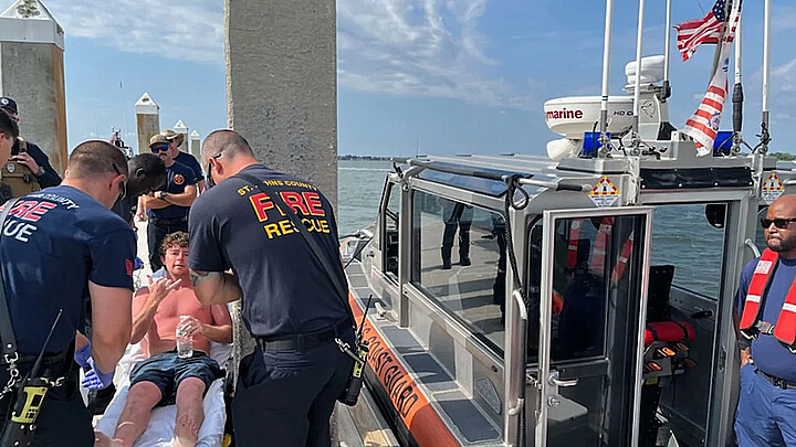 Charles Gregory receives care from EMS after being rescued a dozen miles off Florida's coast on Saturday
