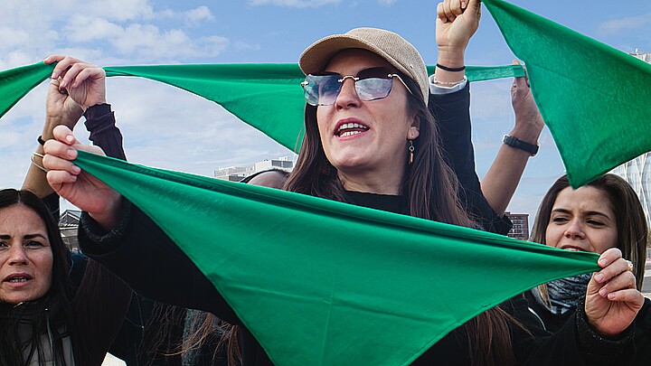 Hispanic women with green scarves on reproductive rights and safe end pegnancy protest in Latin America