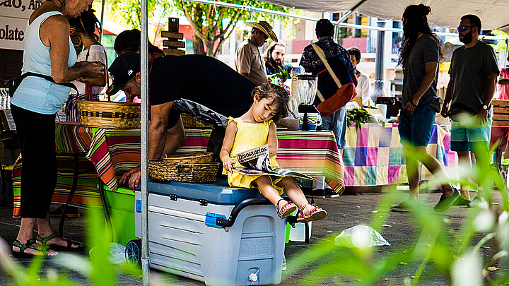 A young girl reads a book at a small Puerto Rican market