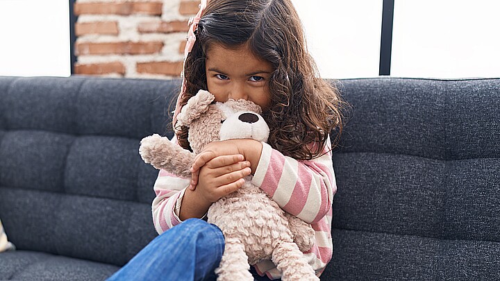 Stock photo of adorable girl kissing and hugging teddy bear