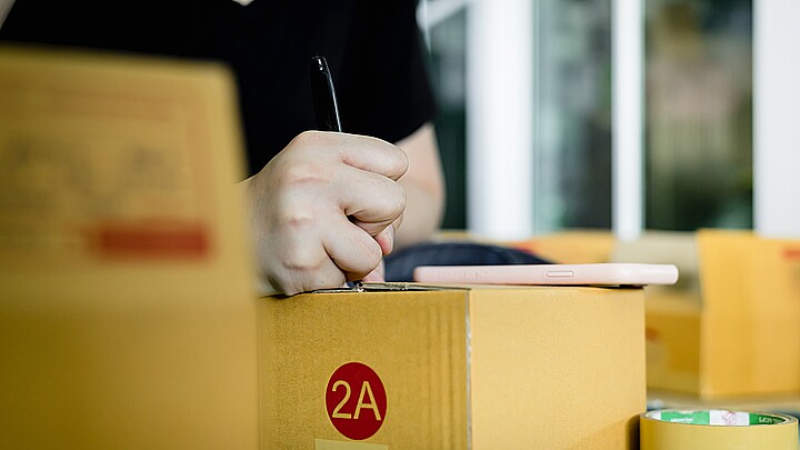 Hombre llenando formulario sobre una caja