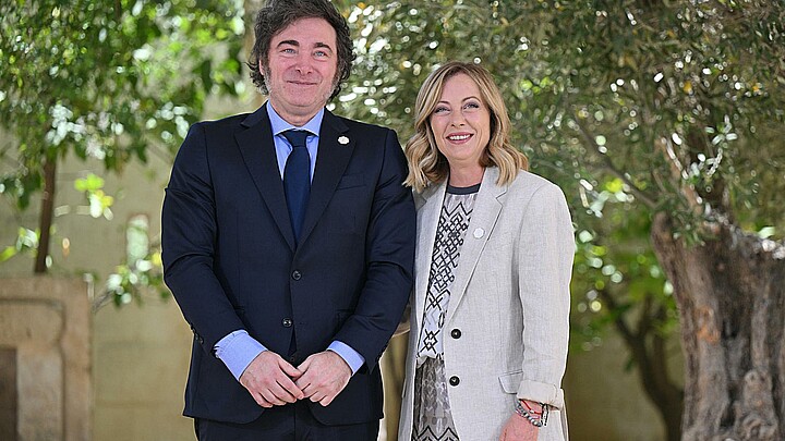 La primera ministra italiana, Giorgia Meloni (d), recibe al presidente argentino, Javier Milei (i), durante la segunda jornada de la cumbre del G7