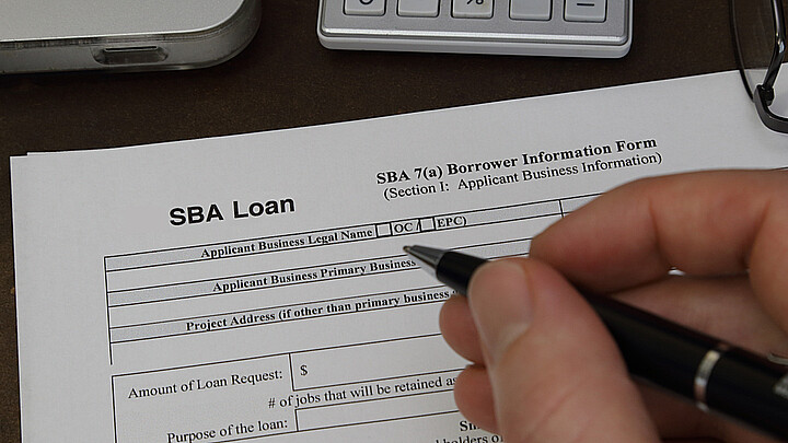 Una persona llenando el formulario de solicitud de crédito para pequeña empresa de la SBA