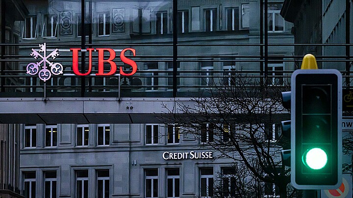  Los logotipos de los bancos suizos Credit Suisse y UBS aparecen en distintos edificios detrás de los semáforos de Zúrich