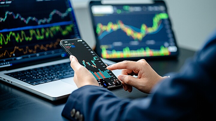 Los inversionistas analizan el índice del mercado de datos a través de la pantalla de un smartphone para comercializar la tabla de acciones para planificar las inversiones, obtener beneficios, el mercado de valores y los datos de criptodivisa, financieros.