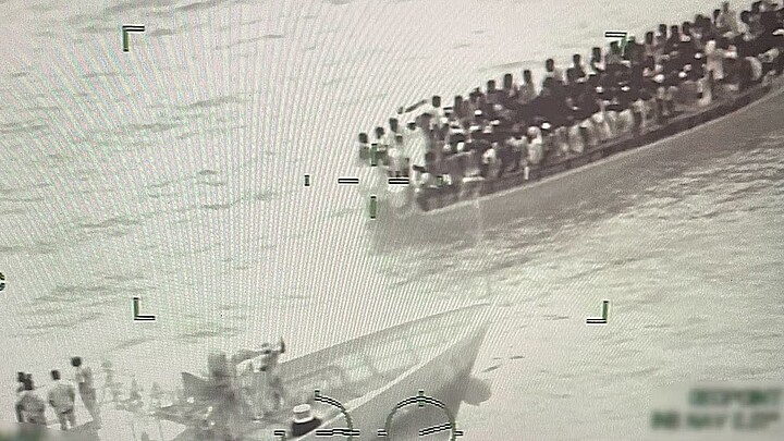 Fotografía del 17 de agosto 2024 cedida por la Guardia Costera de los Estados Unidos de una imagen de control donde aparece parte de la tripulación del buque guardacostas Paul Clark (i) interceptando una expedición de migrantes adosados en una embarcación a 91 kms (57 millas) al sur de las Islas Turcas y Caicos