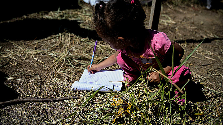 Fotografía fechada el 14 de septiembre de 2017 que muestra a una niña mientras dibuja en un cuaderno. 