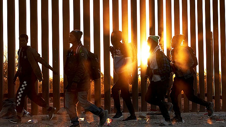 Fotografía de archivo de migrantes que caminan junto al muro en la frontera de EE.UU, y México en Lukeville, Arizona, EE.UU. 