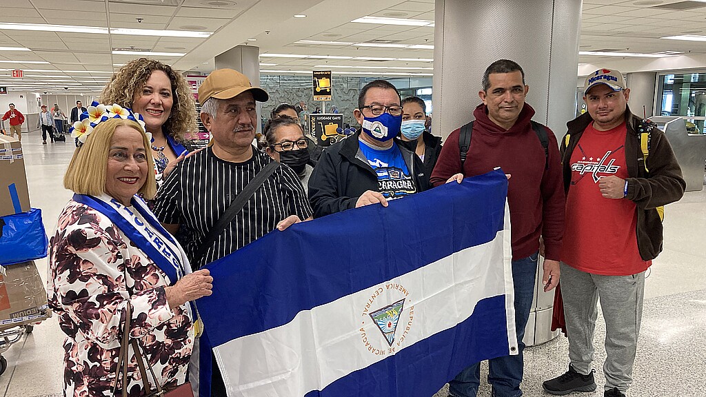 Un grupo de desterrados nicaragüenses sostienen la bandera de su país