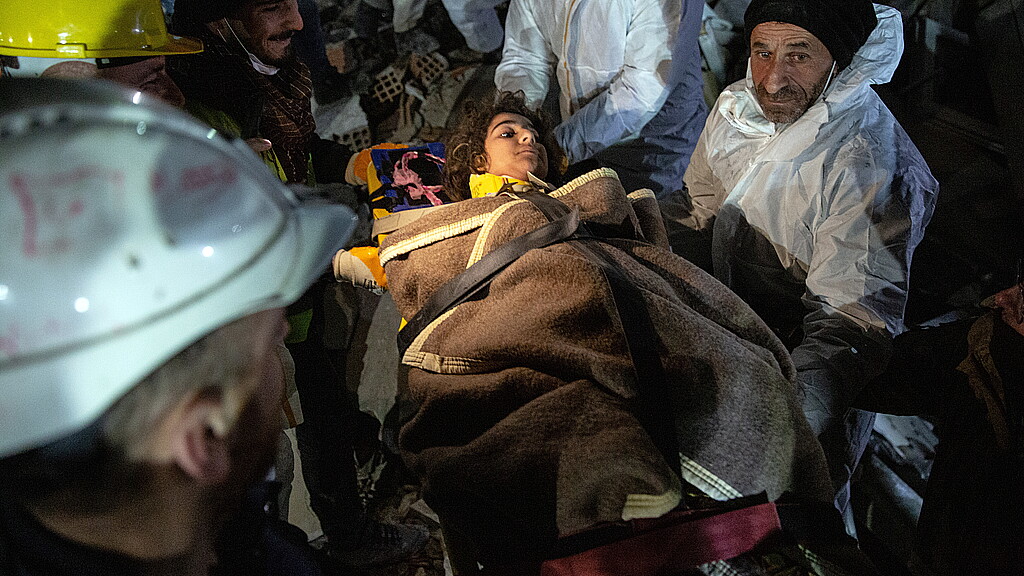 Los equipos de rescate traslandan a una niña de once años en Hatay (Turquía), recuperada de los escombros de un edificio