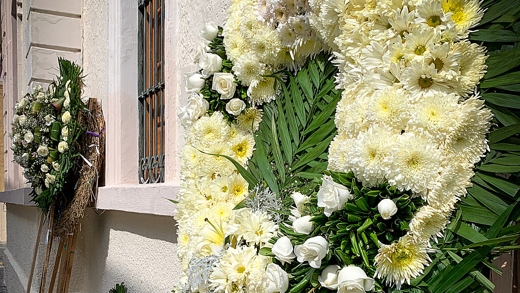 Corona de flores blancas en el exterior de una funeraria