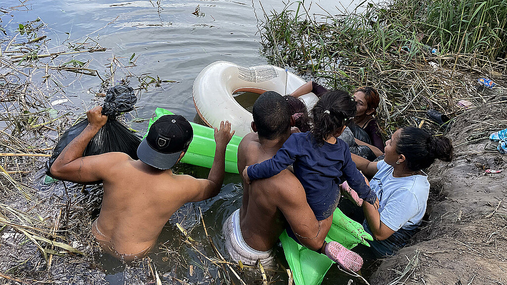 Un grupo de migrantes, ayudados de un inflable, intentan cruzar el Río Bravo el 11 de abril de 2023, en la ciudad de Matamoros en Tamaulipas (México).