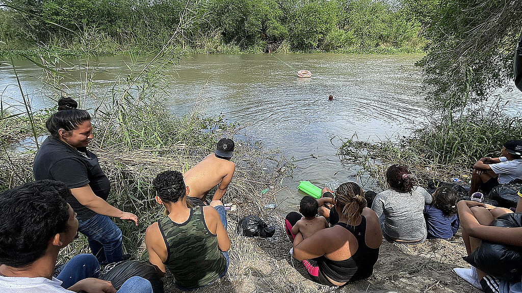 Un grupo de migrantes, ayudados de un inflable, intentan cruzar el Río Bravo el 11 de abril de 2023, en la ciudad de Matamoros en Tamaulipas