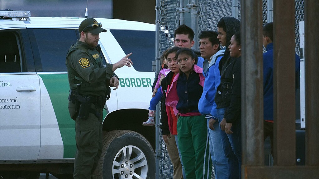 Un agente de la patrulla fronteriza estadounidense habla a un grupo de jóvenes migrantes