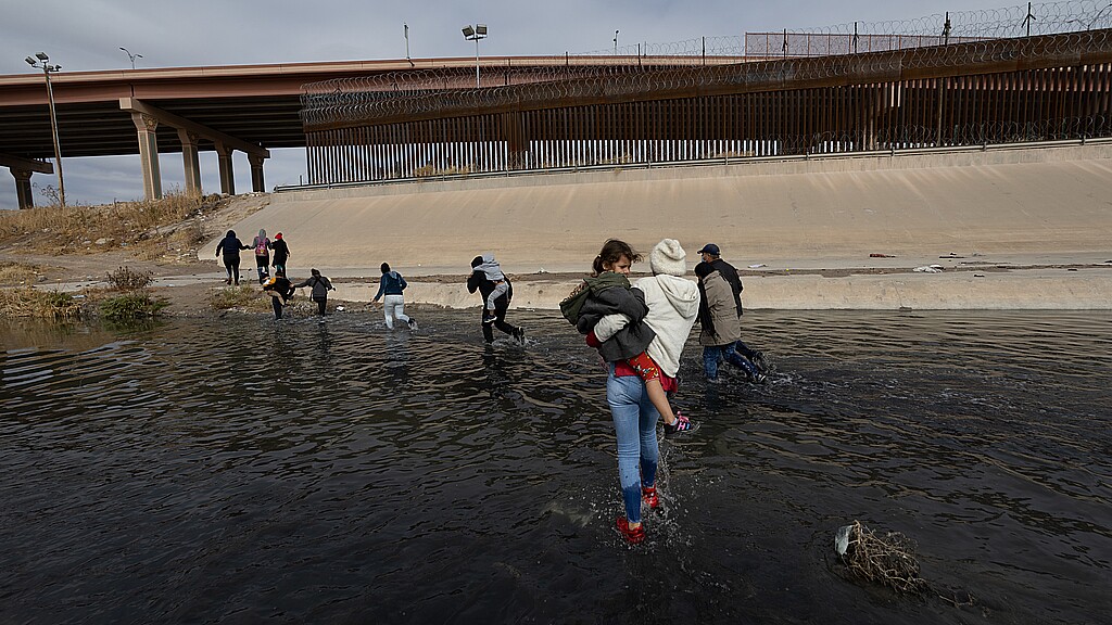 Grupo de migrantes cruzando la frontera de Río Bravo entre México y Estados Unidos