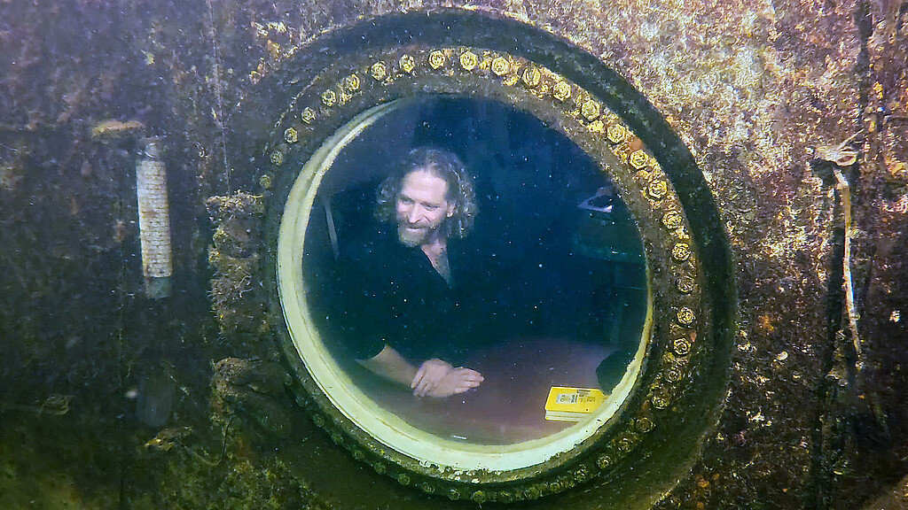 El explorador de buceo e investigador médico, Joseph Dituri (d), mientras saluda al buzo Thane Milhoan (i) desde el Jules' Undersea Lodge