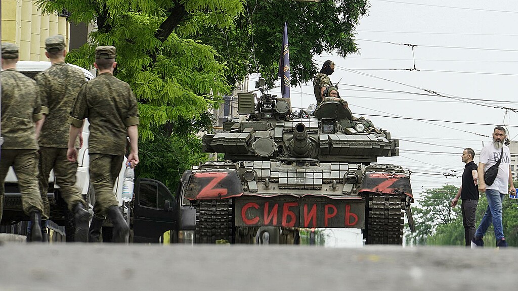 Militares de la empresa militar privada Wagner Group bloquean una calle con un tanque en el que se lee "Siberia"