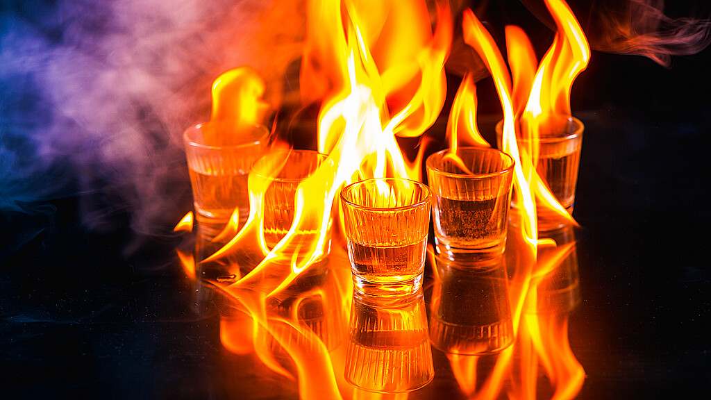 Glasses with burning alcohol on black background