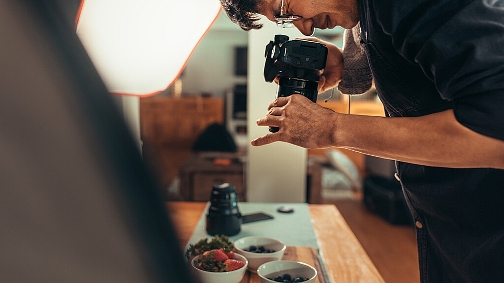 Un fotógrafo varón dispara comida sobre la mesa