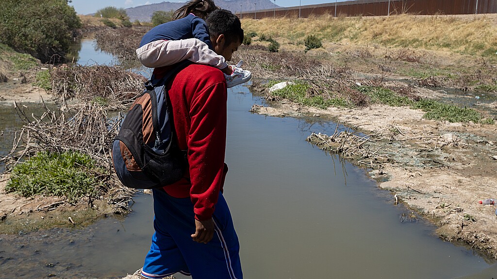 Migrants crossing river