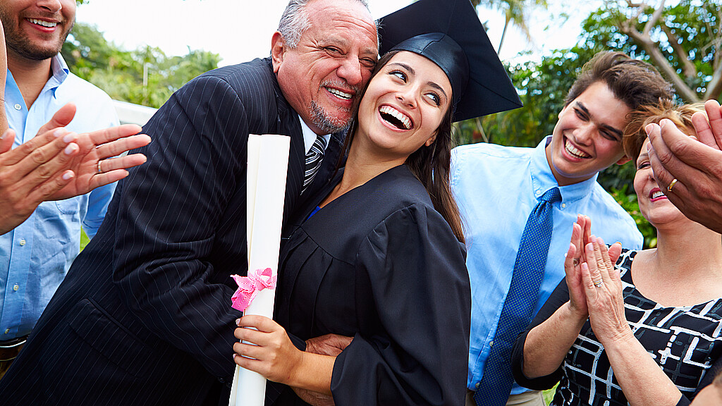 Hispanic student and family celebrating graduation