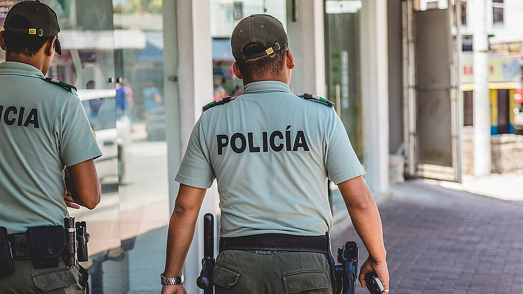Colombian police officers patrol a street circa 2017