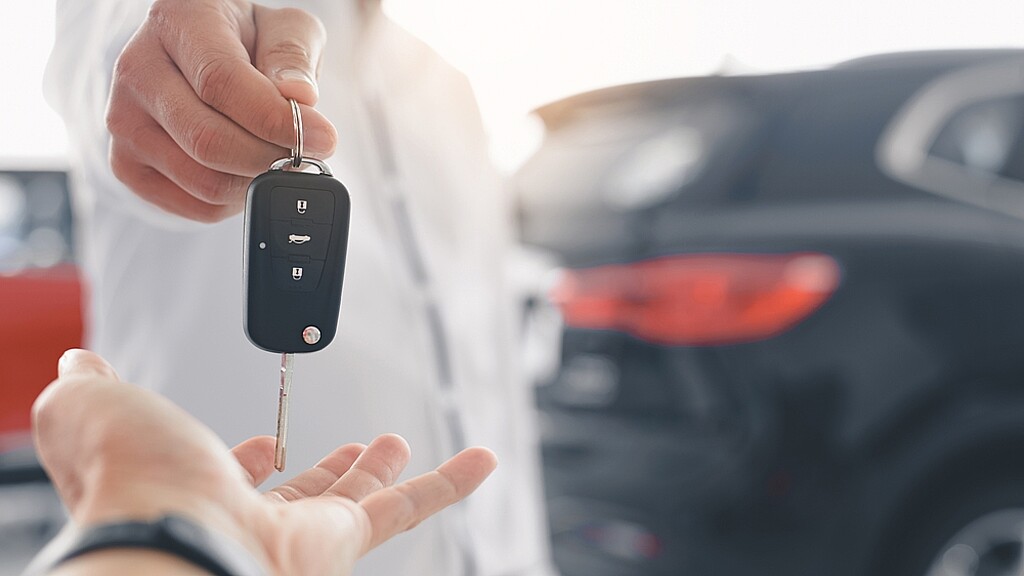 Una mano recibiendo una llaves por la compra de un auto