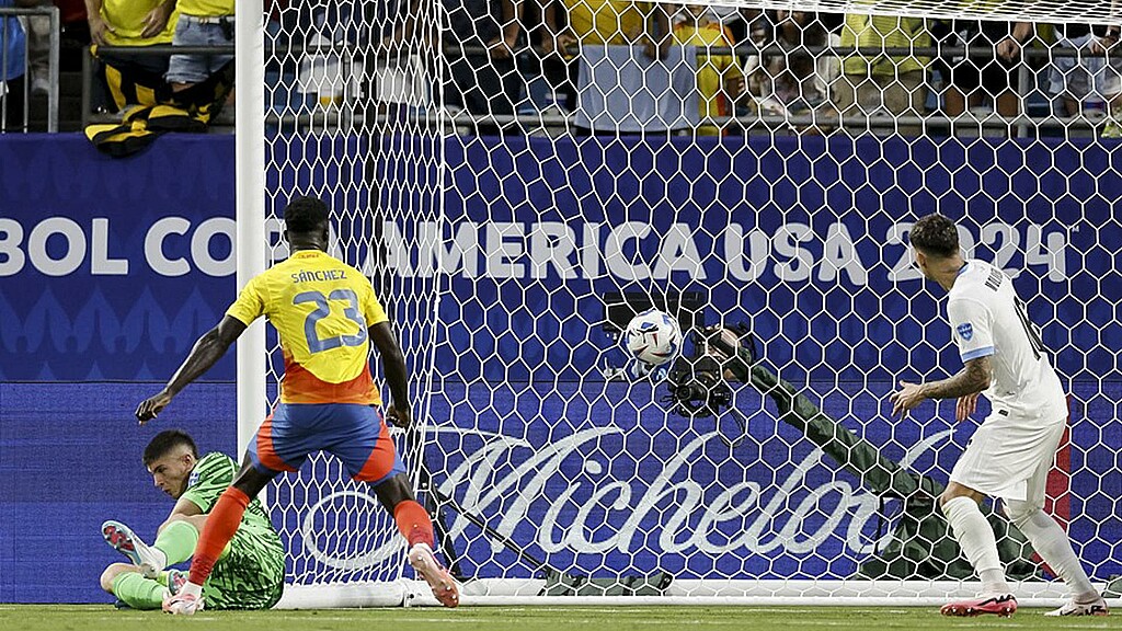 El portero uruguayo Sergio Rochet (I) y Mathias Olivera, así como el colombiano Davinson Sánchez, observan un gol marcado por el colombiano Jefferson Lerma