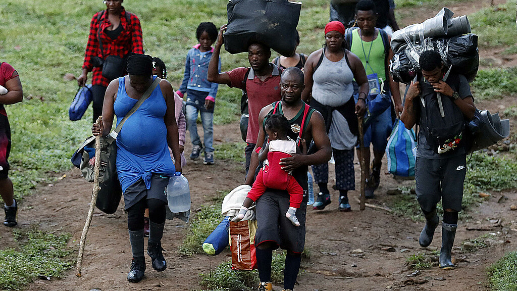 Fotografía de archivo fechada el 28 de septiembre de 2021 que muestra a migrantes haitianos en su camino hacia Panamá por el Tapón del Darién en Acandi (Colombia)