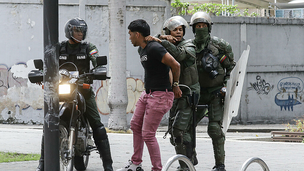 Integrantes de la Guardia Nacional Bolivariana detienen a un manifestante opositor el martes en Caracas (Venezuela).