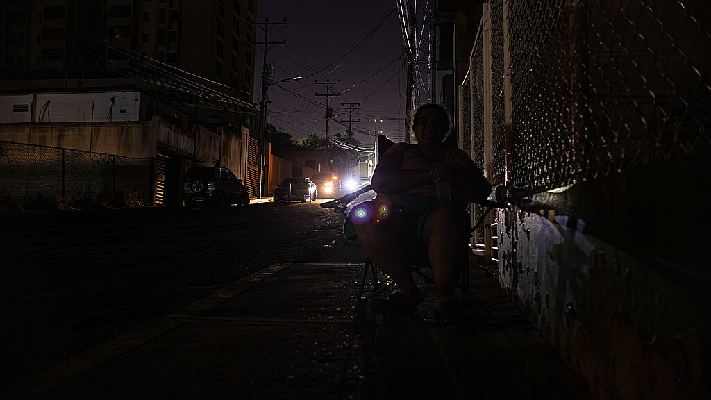 Fotografía de archivo del 29 de febrero de 2024 de una persona que camina en la oscuridad durante un corte eléctrico, en Maracaibo (Venezuela). 